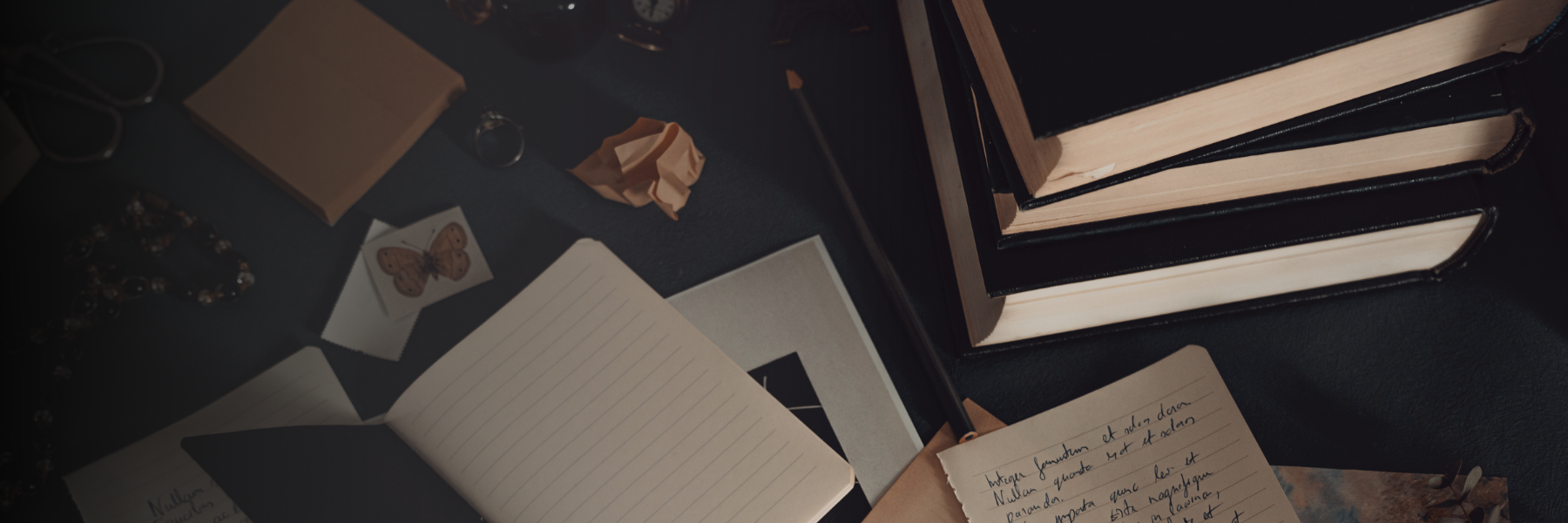 books and paper on a black gradient for Raven Youngblood Author portfolio